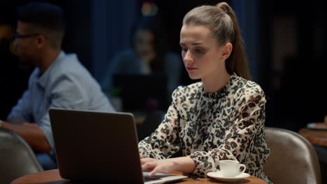 Businesswoman working on laptop in cafe. Freelancer typing on laptop keyboard