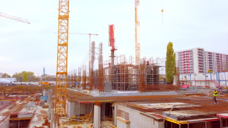 Construction-site-at-sunset-with-cranes-and-workes