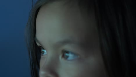 a young girl sits in front of a computer, displaying strong emotions. the scene captures her expressive reaction during an engaging moment, set in a cozy indoor environment