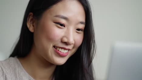 captivating moments: a young woman engaged in an online interaction, reflecting joy and curiosity while utilizing technology in a cozy environment