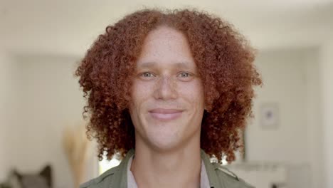 portrait of happy caucasian man with red hair and freckles smiling at home in slow motion