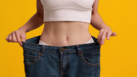 woman showing weight loss in loose jeans