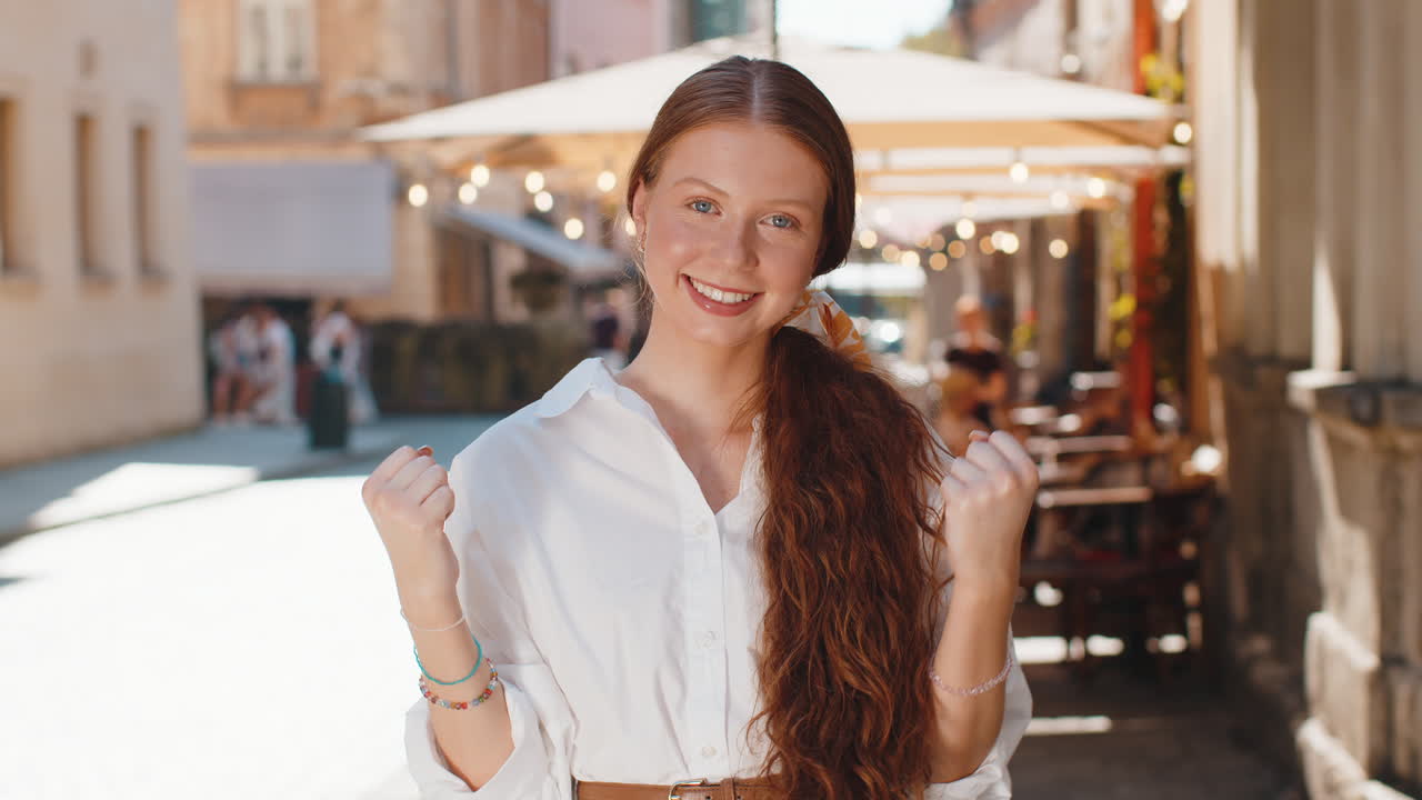 Adult girl shouting celebrating success winning goal achievement good victory news in city street