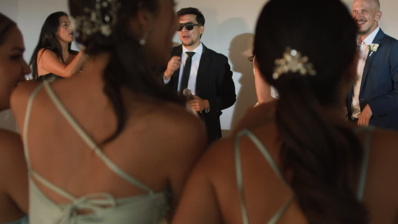 Clip of a wedding where the newlyweds dance happily with their guests and bridesmaids.