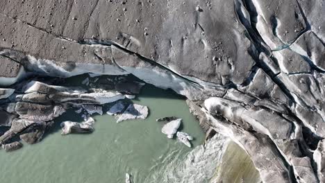 aerial - melting ice at rhone glacier in furka pass, switzerland, showcasing the glacial melt and water flow