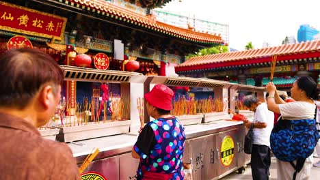 people praying with incense at hong kong temple