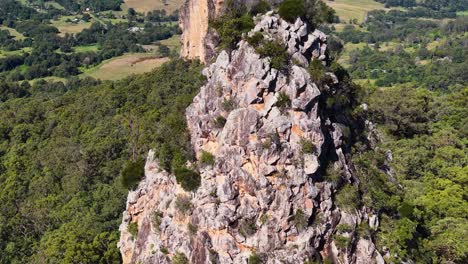 aerial footage of nimbin rocks, showcasing rugged formations amidst vibrant greenery under bright daylight
