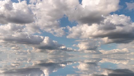 futuristic background consisting of time lapse clip of white fluffy clouds over blue sky and their reflection, video loop