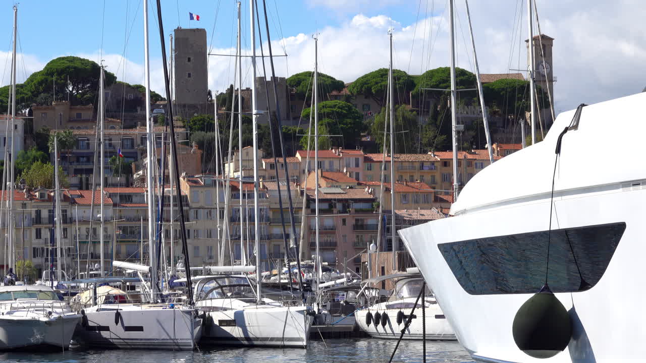 Cannes, France - July 2, 2025: Distant view from the Old Port of a Cannes sign written on a mountain near the Notre Dame d'Esperance church and the Museum of World Explorations