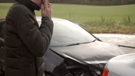 hombre llamando para informar de un accidente automovilístico en una carretera de campo