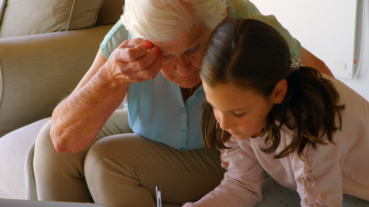 ⁇ 은 백인 할머니가 손녀를 집에서 숙제로 도와주는 전면 전망 4k