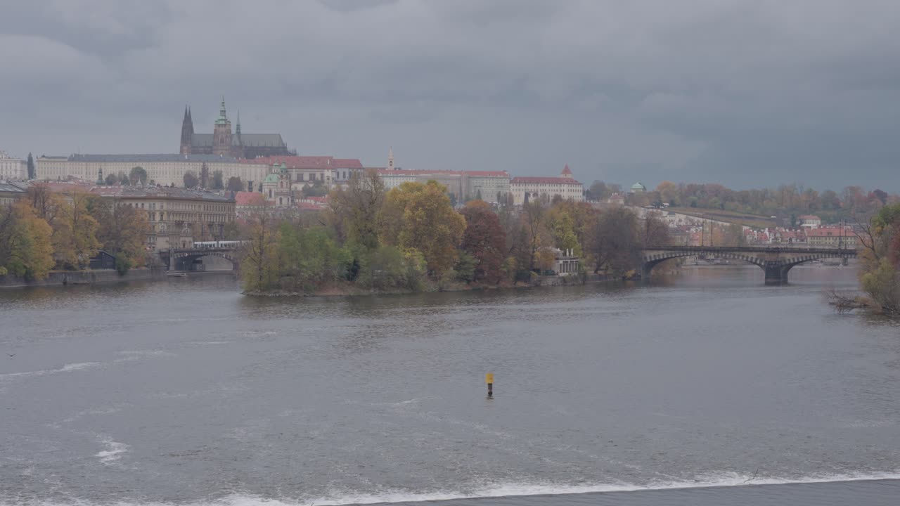 Paesaggio urbano di Praga con fiume, ponte e architettura in una giornata nuvolosa