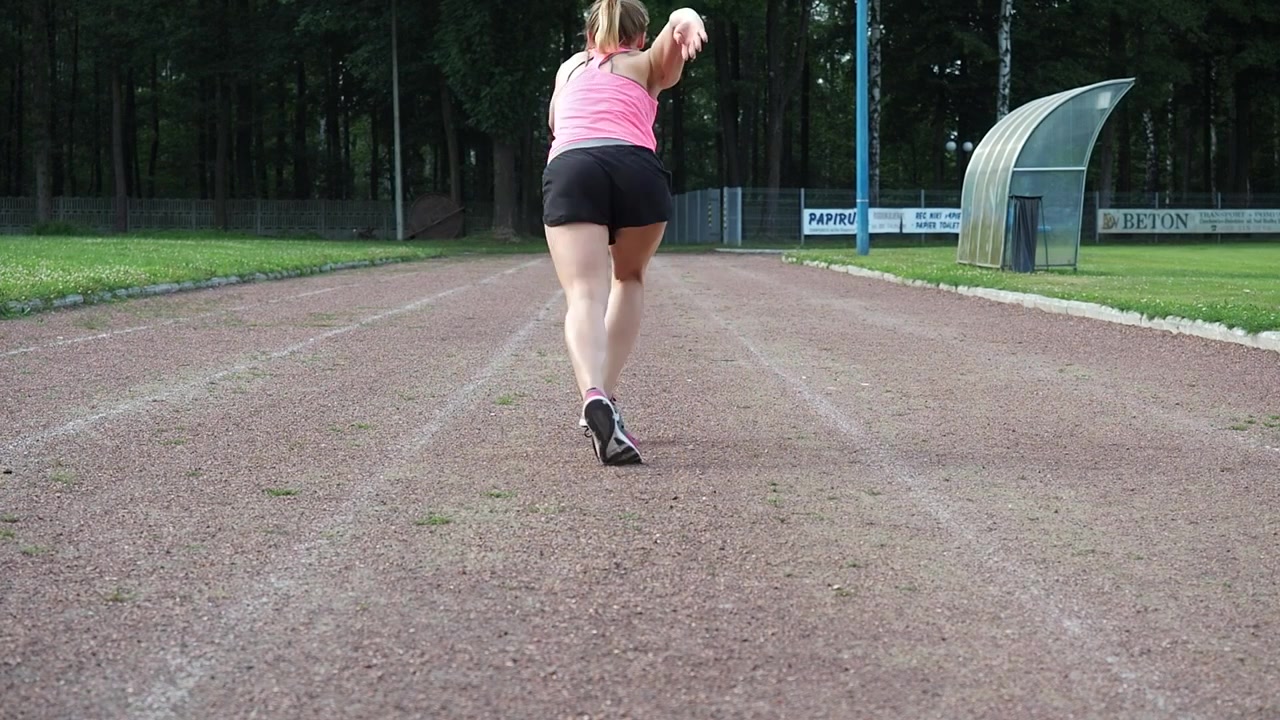 Una donna che corre nello stadio.