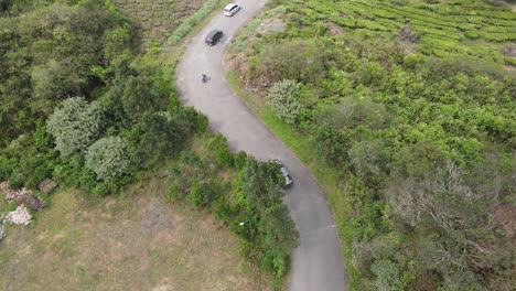 drone tilt up: vista aérea de la carretera en la colina con el vehículo que pasa