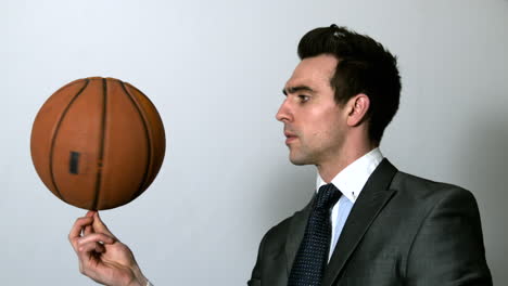 hombre de negocios girando el baloncesto en el dedo