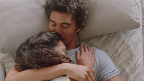 top view young couple lying on sofa embracing sharing romantic relationship enjoying intimacy together at home