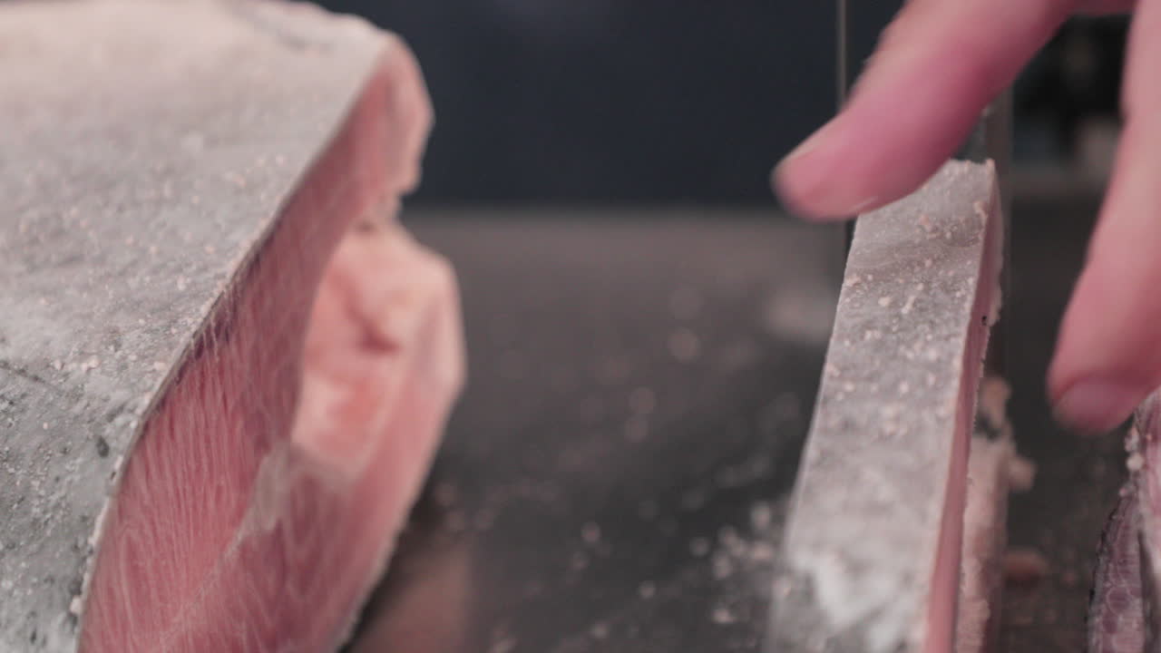 공급 업체는 냉동 연어를 연어 스테이크 컷으로 자릅니다.