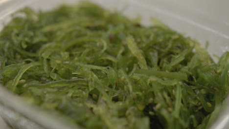 close up of a container of japanese seaweed salad