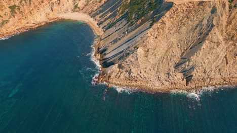 beautiful sunny coastal cliffs over turquoise ocean water drone view. sea waves