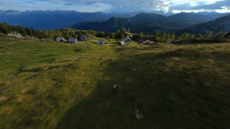 fpv footage was filmed in the slovenian mountain village in the alps with a drone flying fast over mountains filmed with a gopro with surrounding landscapes flying between and over small wooden cabins-1