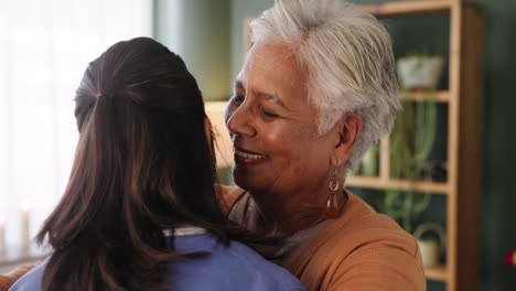 a senior woman receiving a hug from her caregiver