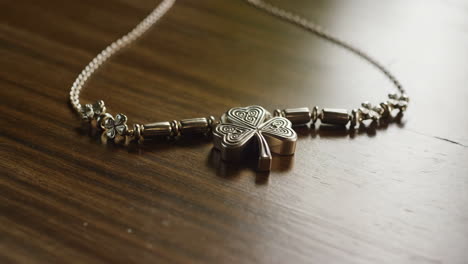 silver shamrock necklace on a wooden table