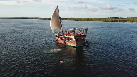 aerial of people jumping off sailing boat. summer vacation in watamu, kenya