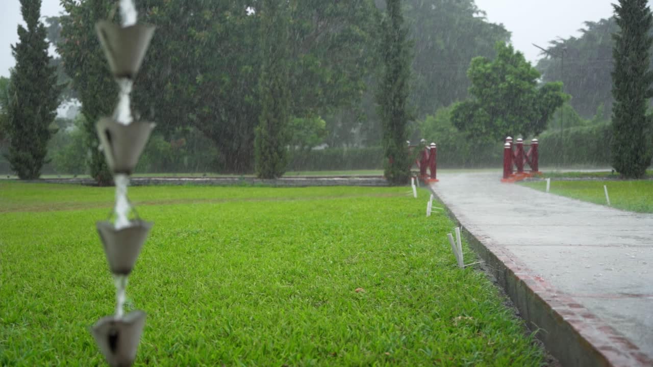 el agua gotea por la cadena de lluvia. mano