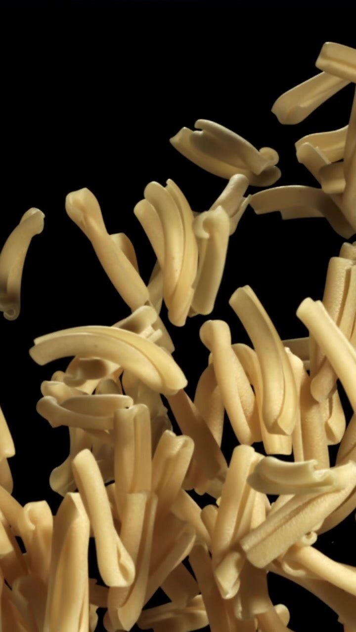 Uncooked Pasta Falling in Slow Motion Against a Black Background