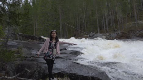 girl reaching out to waterfall. slowmotion