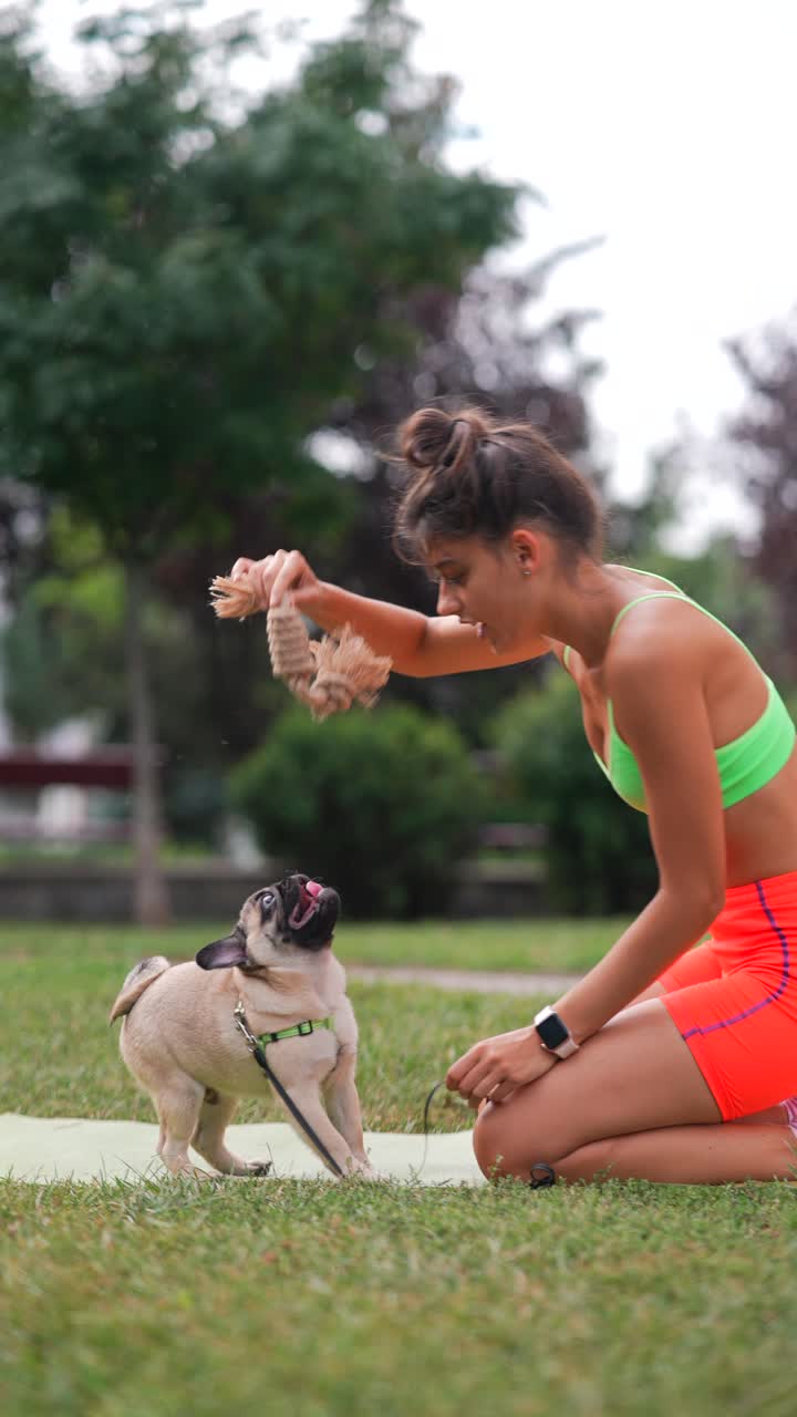 공원에서 퍼그 강아지와 놀고 있는 여자