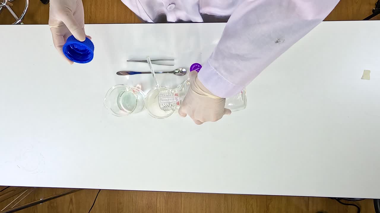 A scientist conducts a chemical experiment with potassium permanganate, showcasing color changes in a controlled laboratory setting