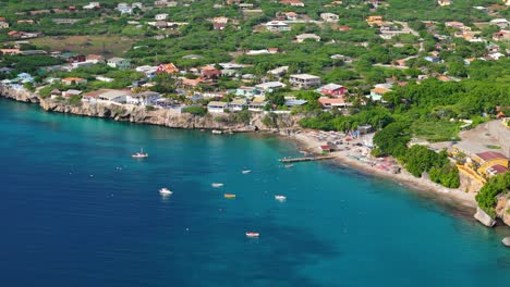 aerial overview of playa piskado as boats and swimmers enjoy caribbean water of curacao