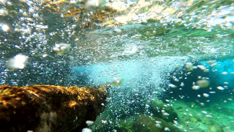 vista submarina del río, agua dulce clara, madera vieja y burbujas de oxígeno