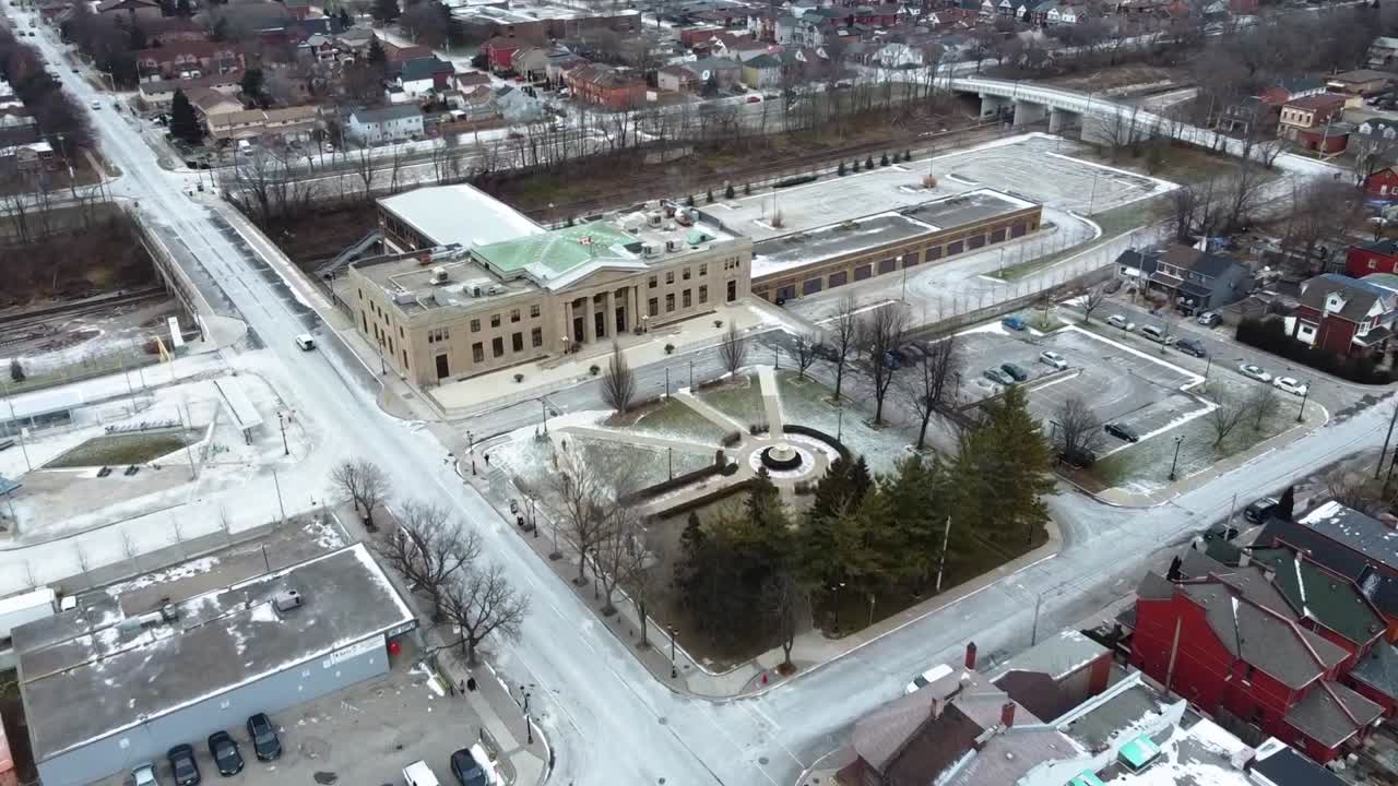 кадр с воздуха, пролетающий над заснеженным парком возле железнодорожной станции в гамильтоне