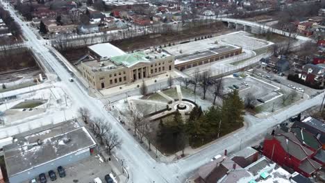 Toma-Aérea-Volando-Sobre-Un-Parque-Nevado-Cerca-De-Una-Estación-De-Tren-En-Hamilton