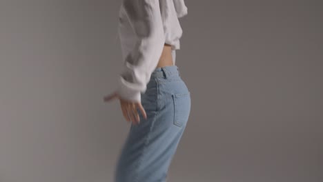 studio shot of young woman having fun dancing against grey background