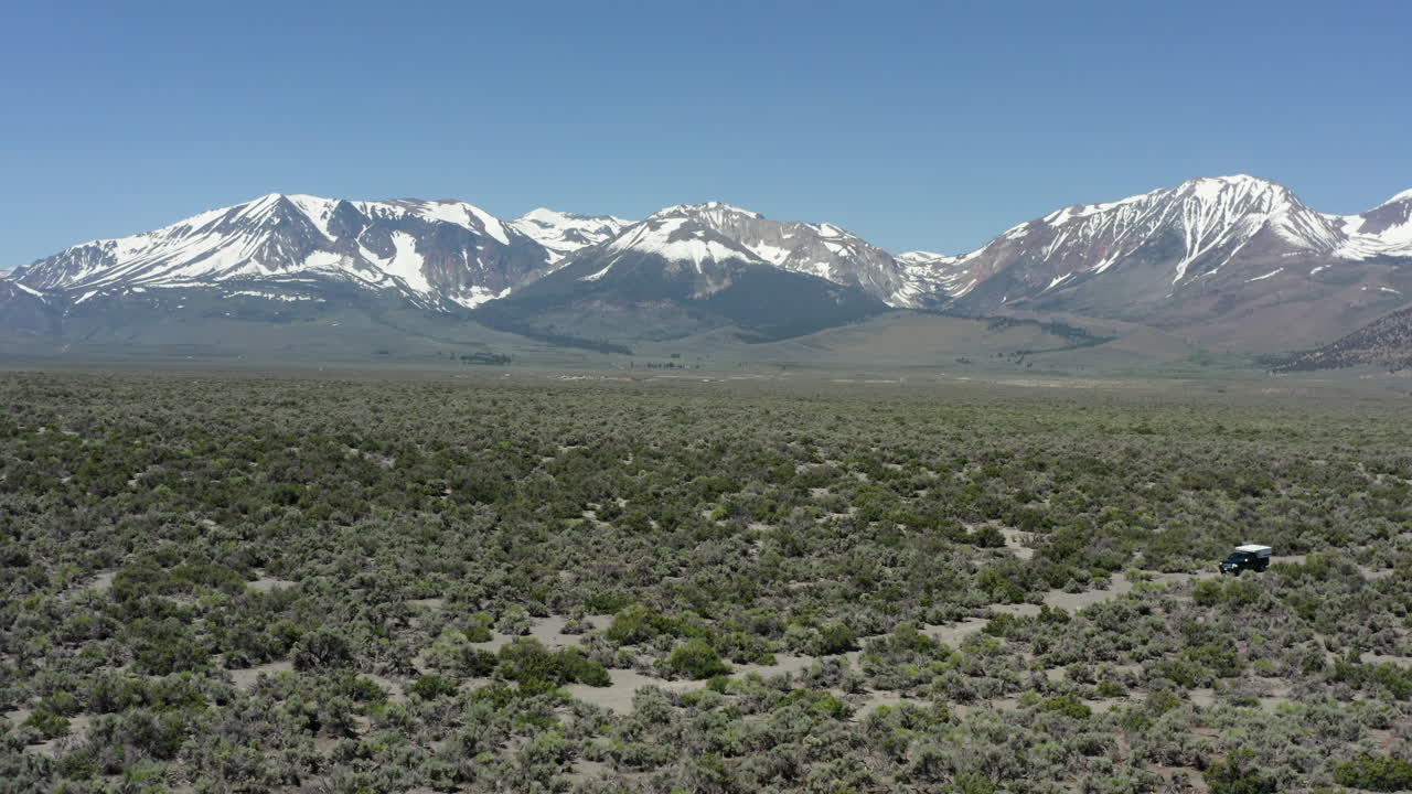 fotografía amplia de las montañas de la sierra nevada con un coche de pie en el paisaje del desierto