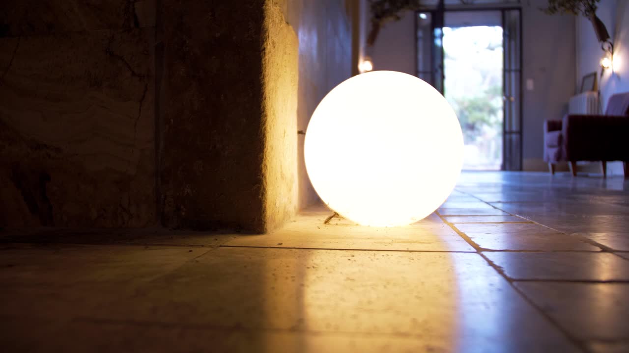 ball of light placed on the floor against a corner of the wall which serves as lighting for the room