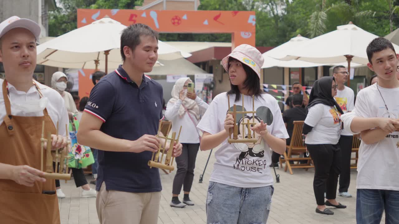 People playing angklung at an outdoor event
