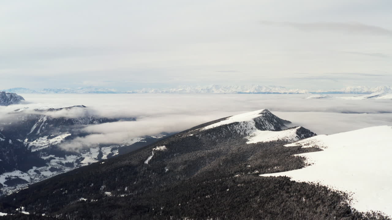 fotografía aérea volando sobre la nevada cordillera de seceda en los alpes italianos en un día nublado