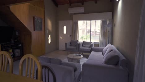 general right slider clip presenting cozy house dining and living room with shades of grey and brown, and shining window in background. shot on 4k.