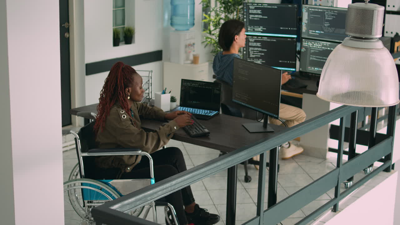 African american app developer in wheelchair analyzing software program