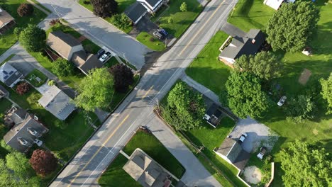 quiet serene atmosphere in suburb neighborhood of american town. aerial top down. roofing flight of houses and homes with well-kept garden at sunset. summer days in united states