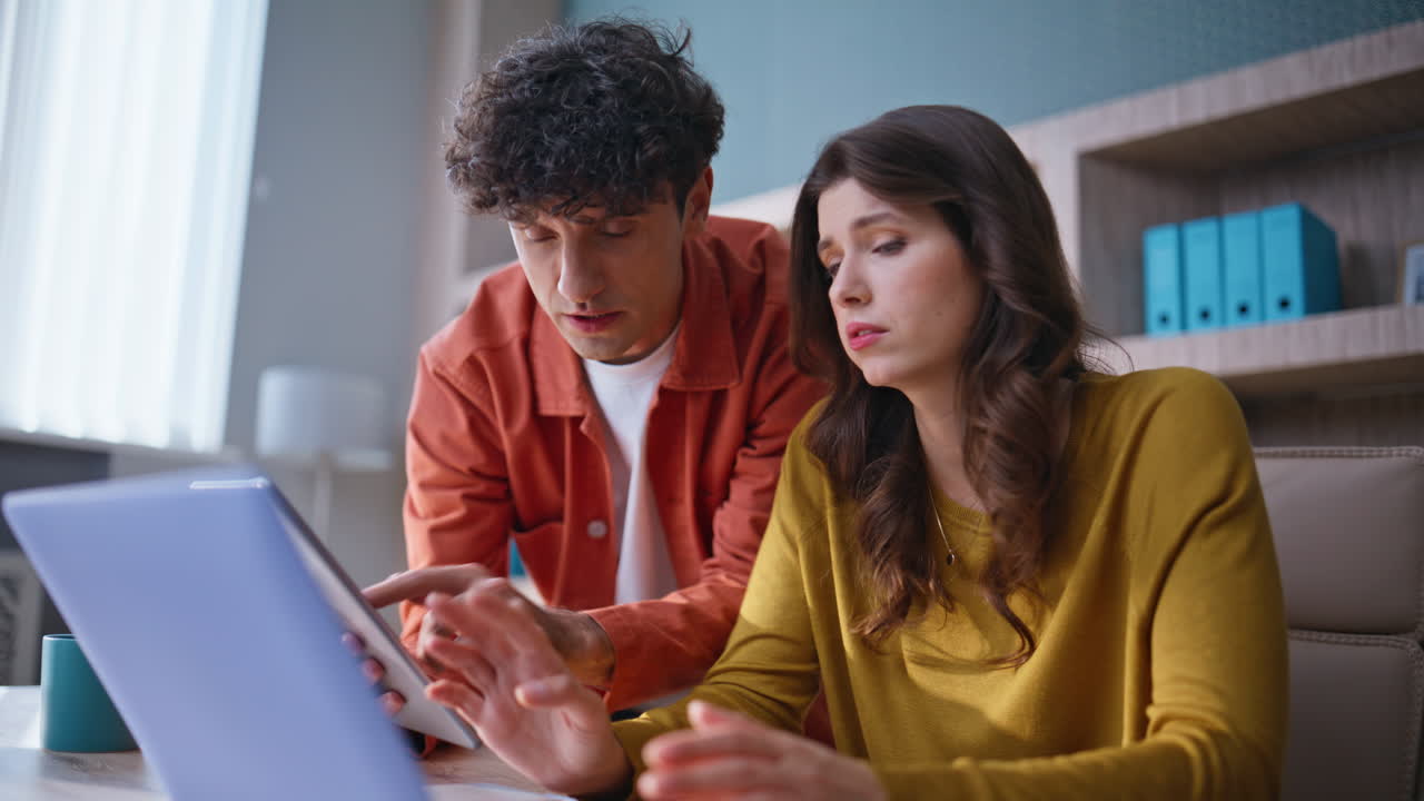 Two professionals worried project looking laptop together at workplace closeup