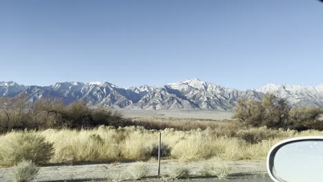 view of east sierra nevada mountains from a car driving on the highway