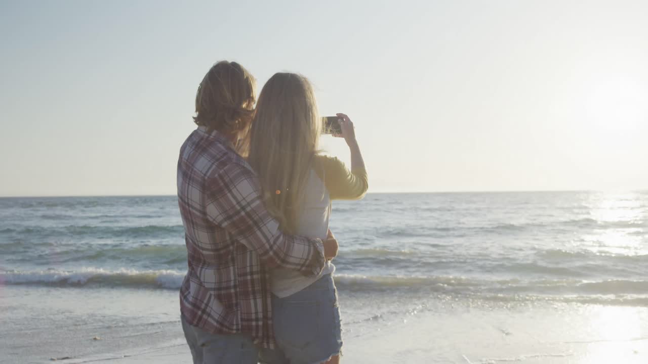 pareja caucásica disfrutando de su tiempo en la playa