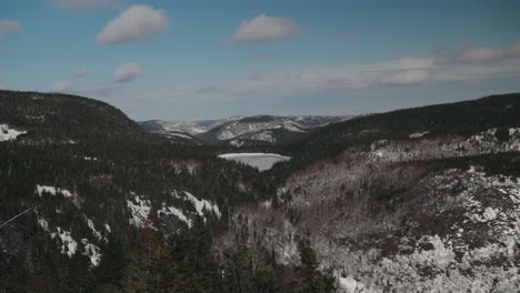 Frozen-Lake-In-The-Middle-Of-Pine-Forest-Mountains-At-Mont-du-Dome-In-Quebec,-Canada