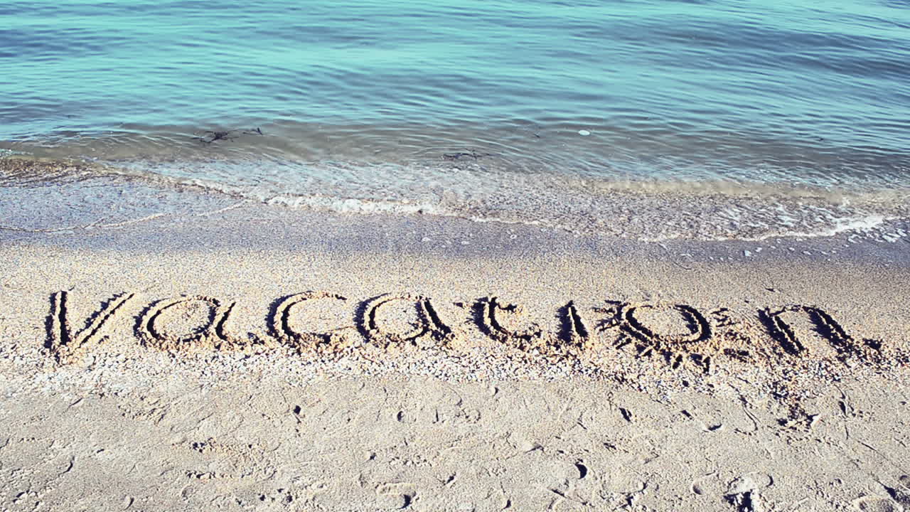 La scritta "Vacanza" sulla sabbia. Scritta sulla sabbia