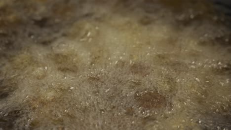 macro shot of delicious falafel fried in oil, making hot bubbles